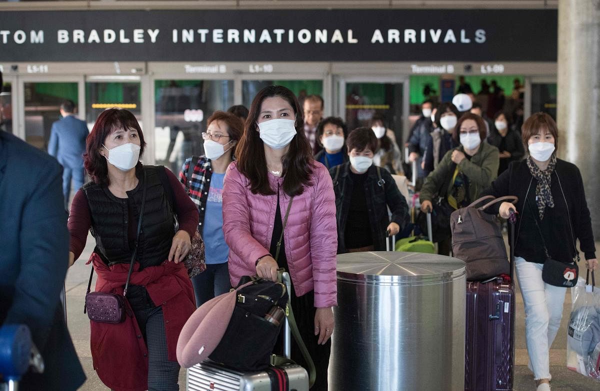 Passengers wear protective masks to protect against the spread of the Coronavirus (AFP Photo)