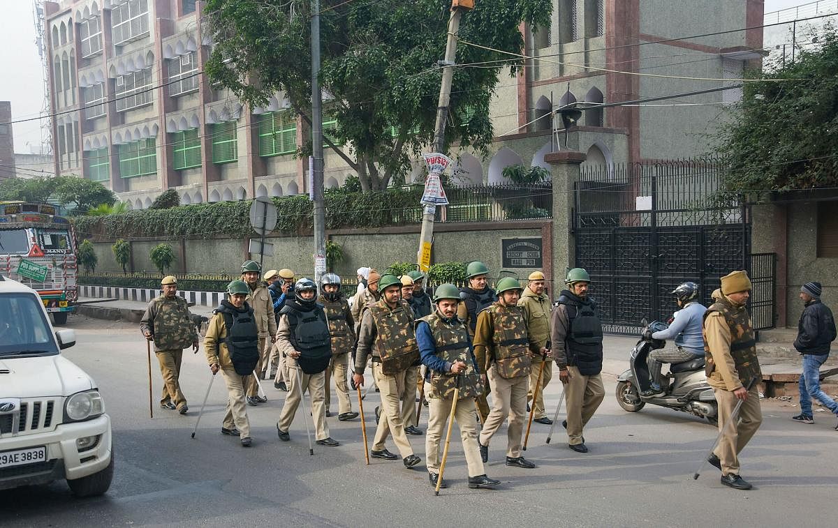 Delhi police personnel patrol a street. (PTI photo)