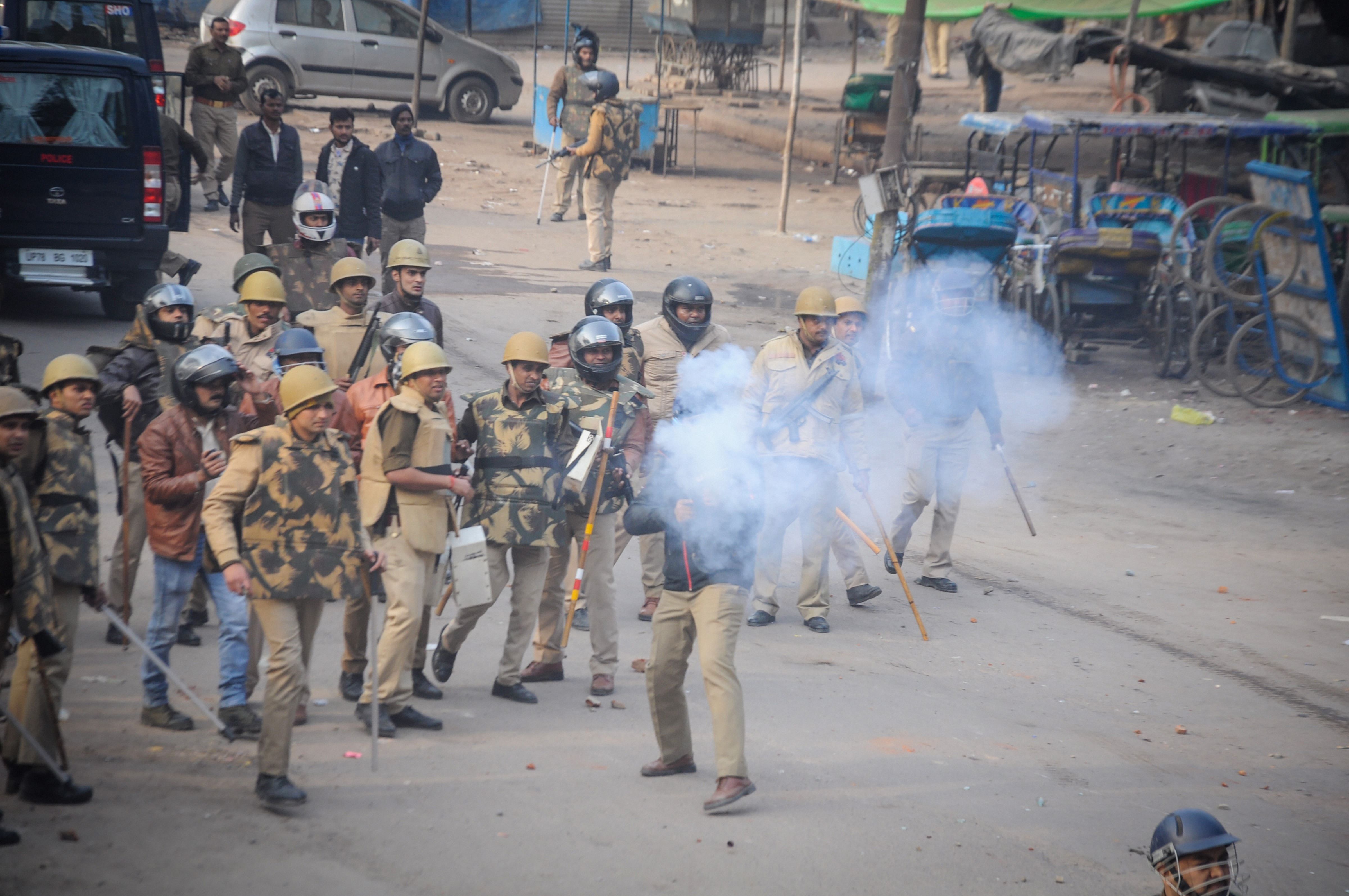Police personnel fire tear gas shells during a protest against the Citizenship (Amendment) Act, at Babu Purwa in Kanpur. (PTI Photo)
