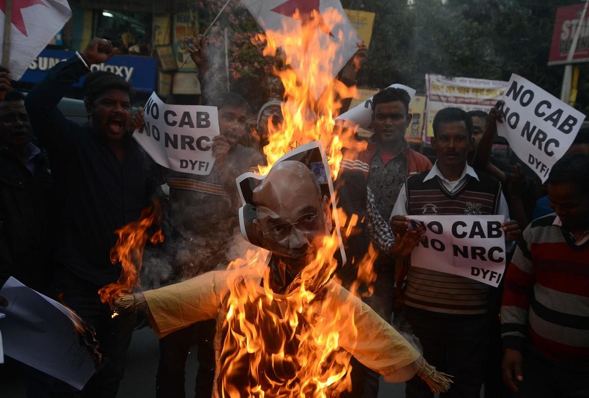 Indian left wing activists of Democratic Youth Federation of India (DYFI) shout slogans as they burn an effigy of India's Home Minister Amit Shah during a demonstration against the Indian government's Citizenship Amendment Bill in Siliguri. (AFP Photo)
