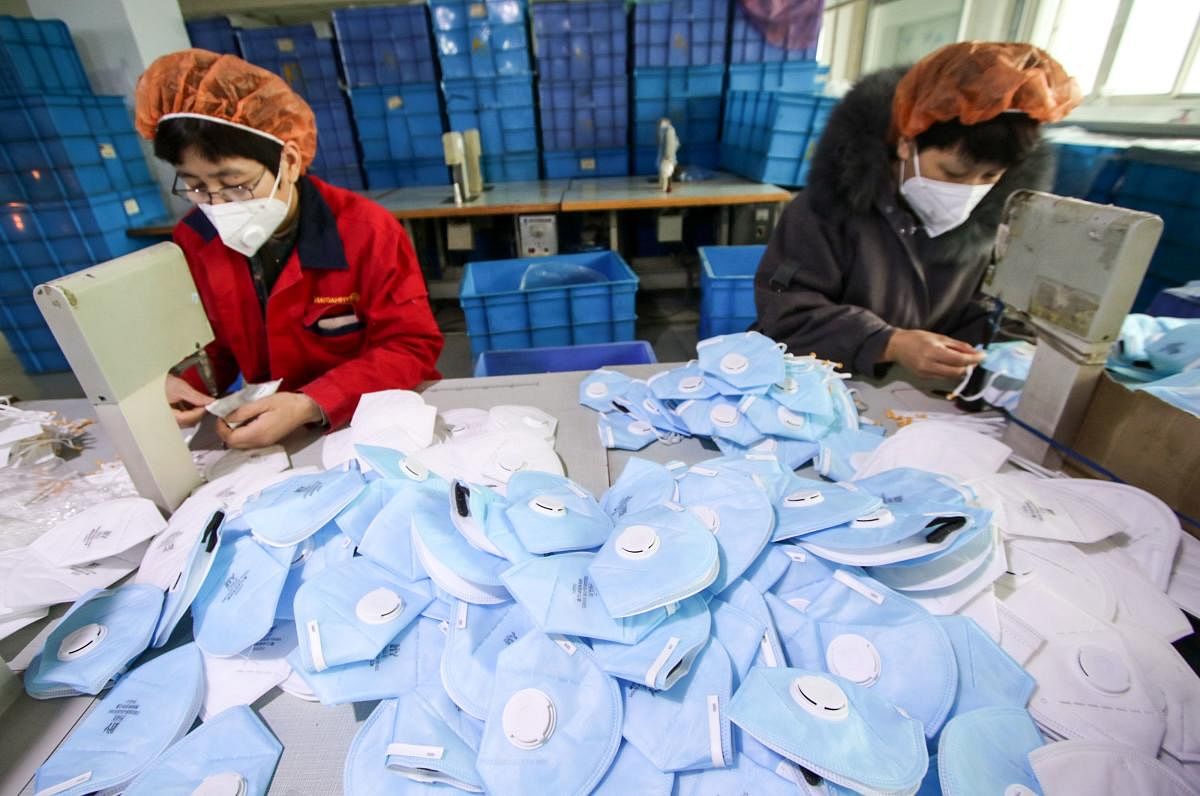 This photo taken on January 22, 2020 shows workers producing facemasks at a factory in Handan in China's northern Hebei province. AFP