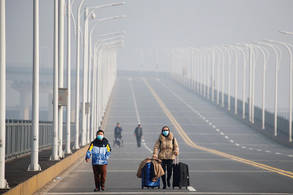 A mother and her son arrive from Hubei province at a checkpoint at the Jiujiang Yangtze River Bridge in Jiujiang. Reuters
