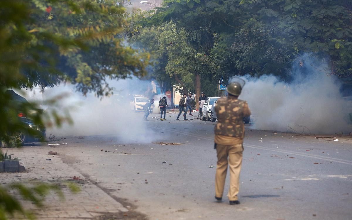 Policeman fires teargas shells at protestors of Citizenship Amendment Act at Mathura Road. PTI