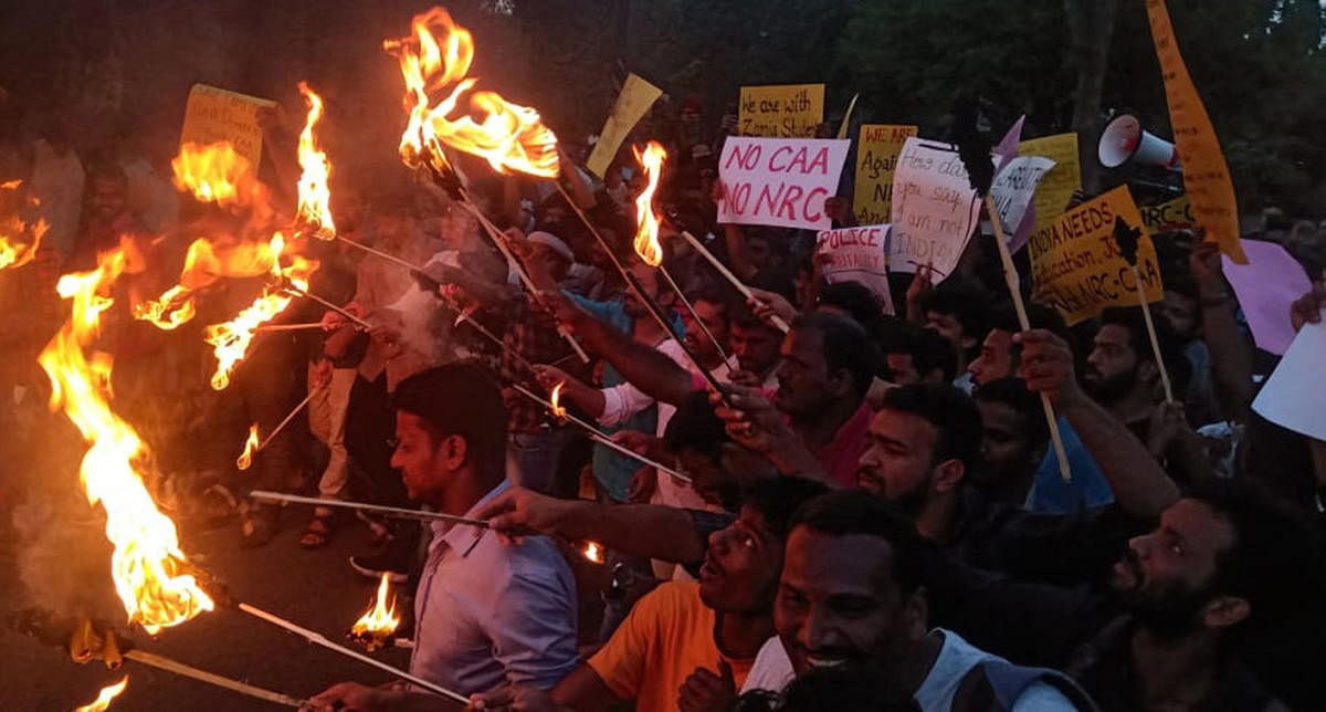 Students of the University of Mysore (UoM) stage a torchlight protest against Citizenship (Amendment) Act, at Manasagangothri, in Mysuru, on Tuesday evening.