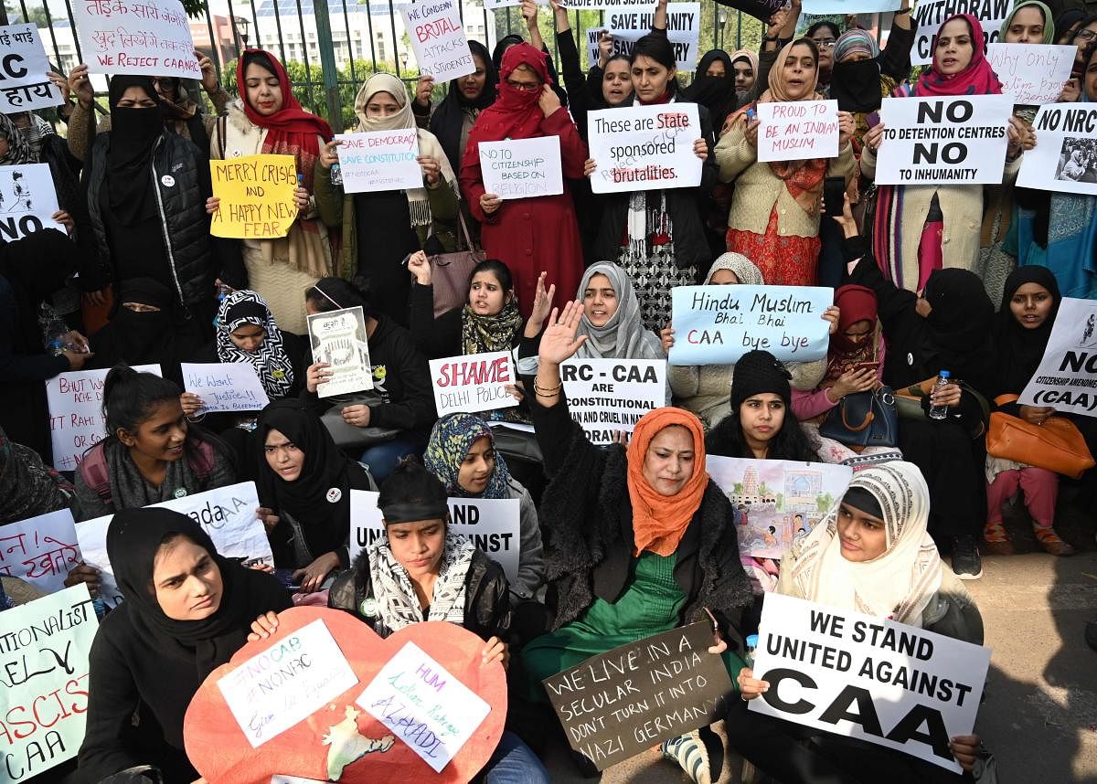 Students and supporters hold placards as they protest outside Jamia Millia Islamia university over India’s new citizenship law in New Delhi on December 18, 2019. (Photo by AFP)