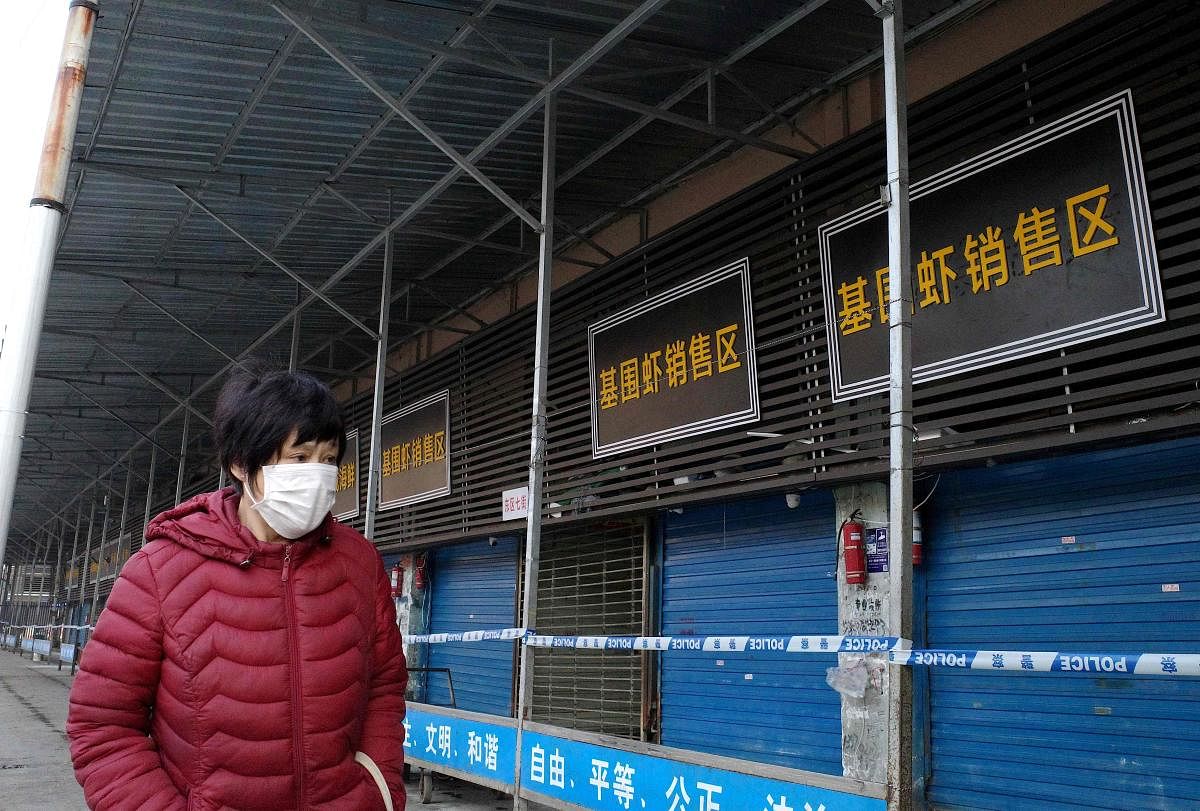 A woman walks in front of the closed Huanan wholesale seafood market, where health authorities say a man who died from a respiratory illness had purchased goods from, in the city of Wuhan, Hubei province, on January 12, 2020. (AFP Photo)