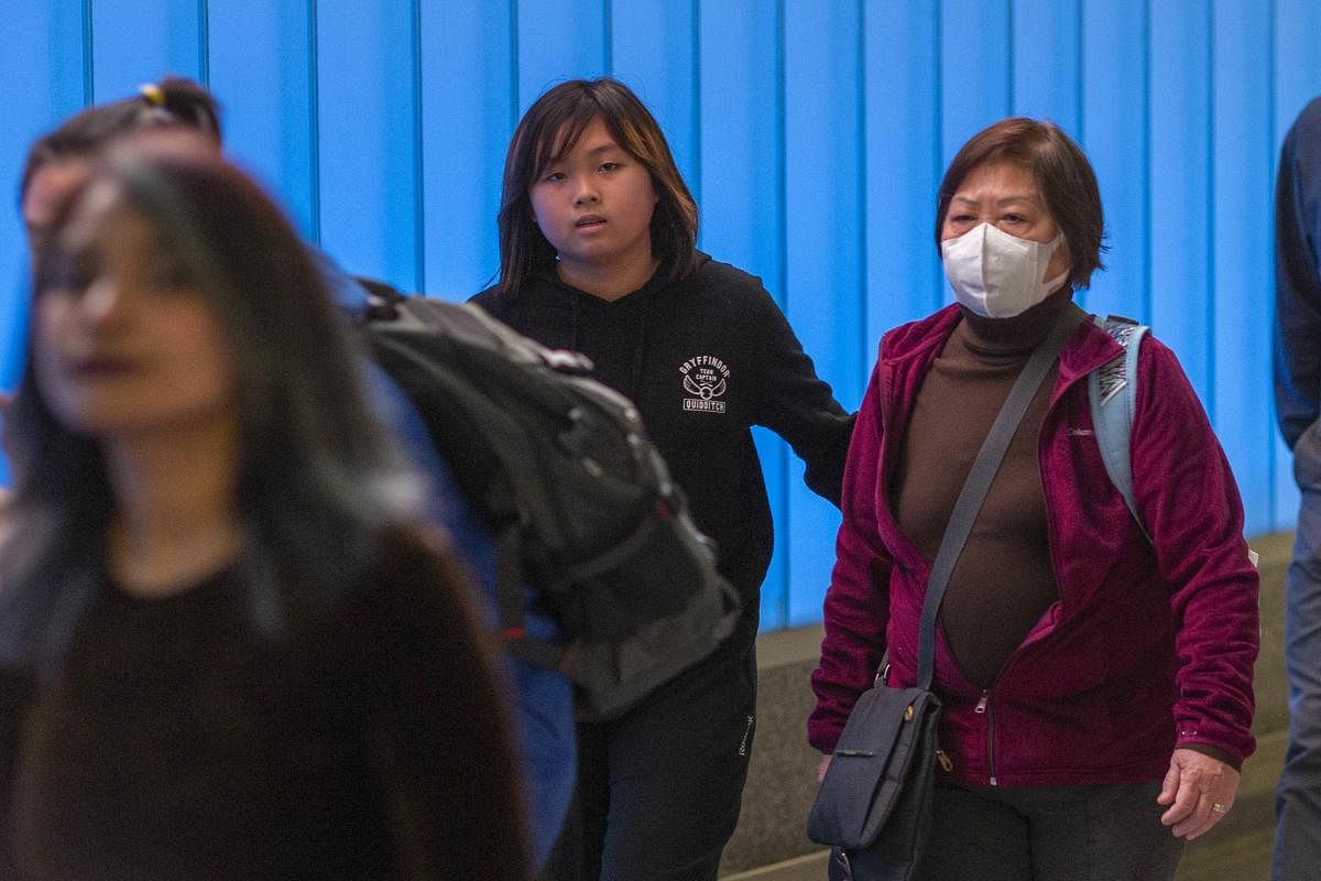 A woman arriving on an international flight to Los Angeles International Airport wears a mask on the first day of health screenings for coronavirus of travelers from Wuhan, China on January 18, 2020 in Los Angeles, California. (AFP Photo)