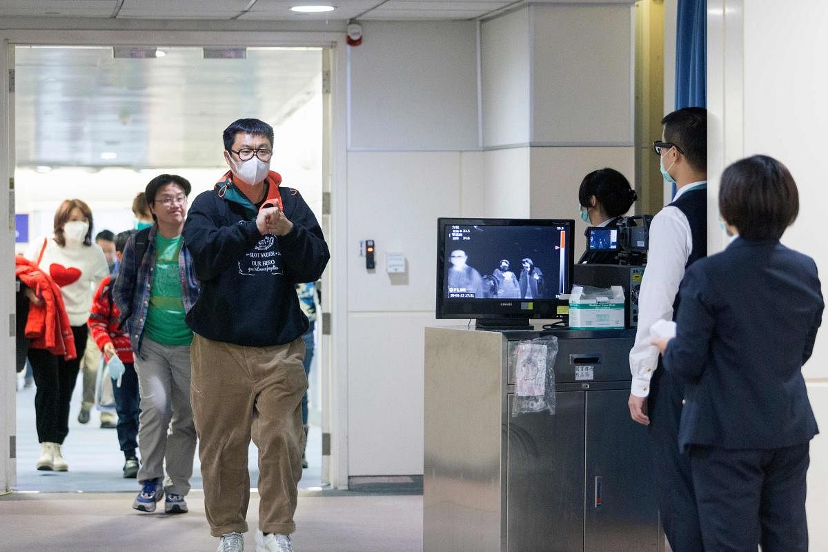This picture taken on January 13, 2020 shows Taiwan's Center for Disease Control (CDC) personnel (R) using thermal scanners to screen passengers arriving on a flight from China's Wuhan province. (AFP Photo)