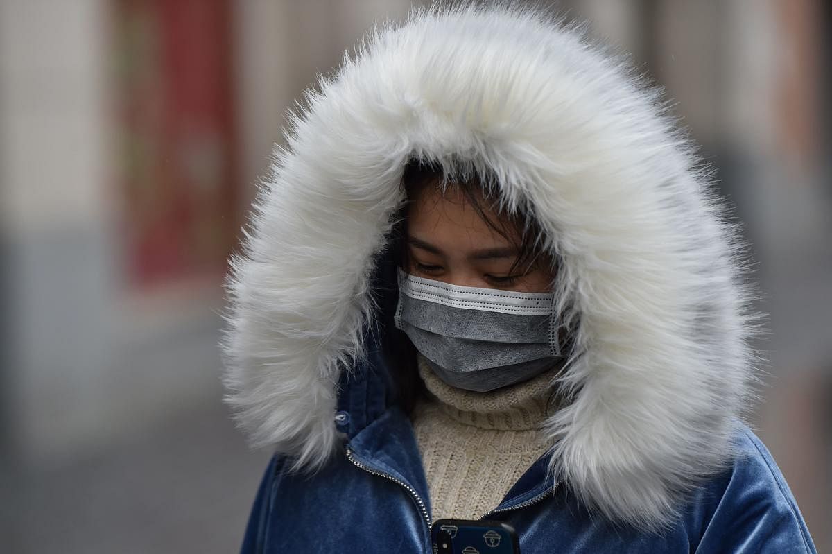 A woman wearing a protective facemask to help stop the spread of a deadly virus which began in the city, walks on a street in Wuhan in China's central Hubei province on January 25, 2020. (AFP Photo)