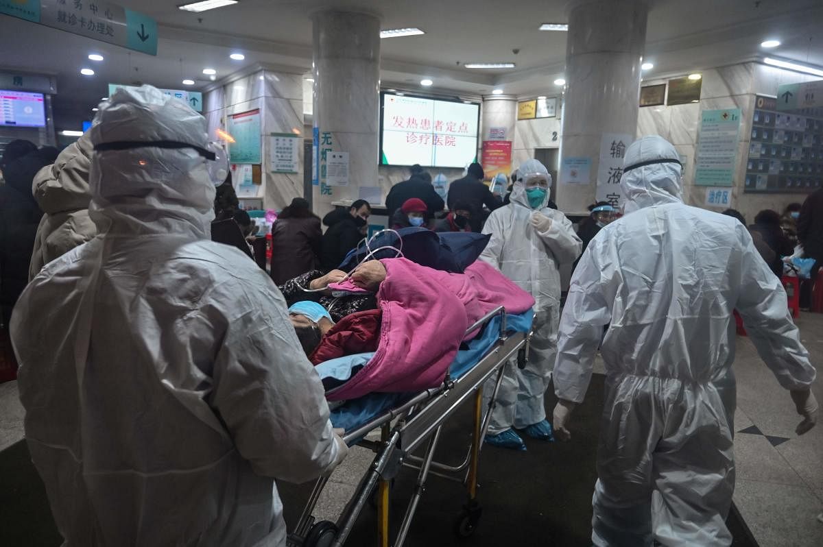 In this photo taken on January 25, 2020, medical staff wearing protective clothing to protect against a previously unknown coronavirus arrive with a patient at the Wuhan Red Cross Hospital in Wuhan. (AFP Photo)
