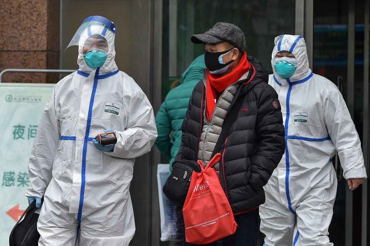 Medical staff wearing clothing to protect against a previously unknown virus walk outside a hospital in Wuhan on January 26, 2020. (AFP Photo)