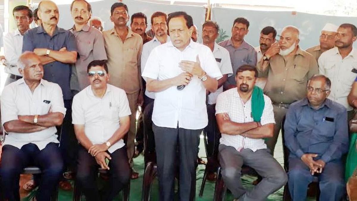 Former minister Kimmane Ratnakar met the Sakahara Sarige employees, who are protesting in front of talukoffice, in Koppa on Wednesday. DH photo