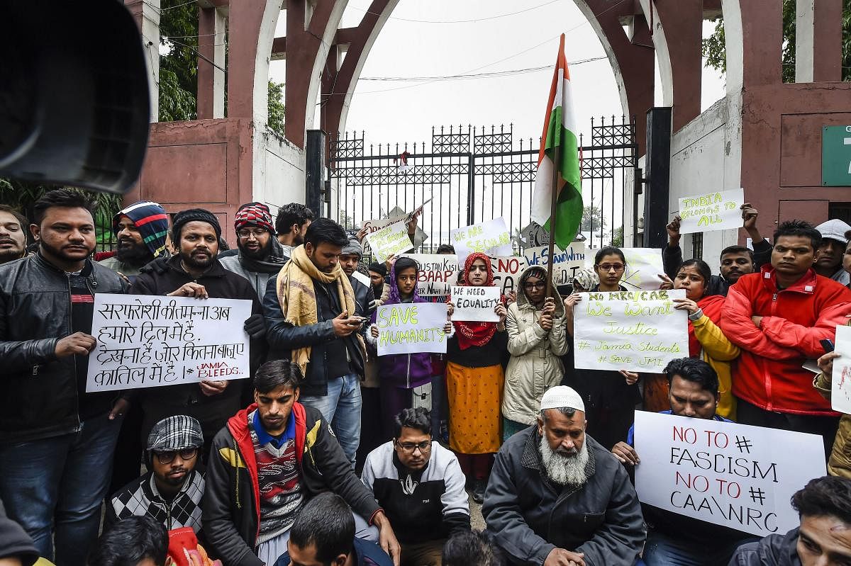 Students along with general public hold placards during a protest against the Citizenship Amendment Act (CAA), outside Jamia Millia Islamia University in New Delhi, Tuesday, Dec. 17, 2019. Photo/PTI