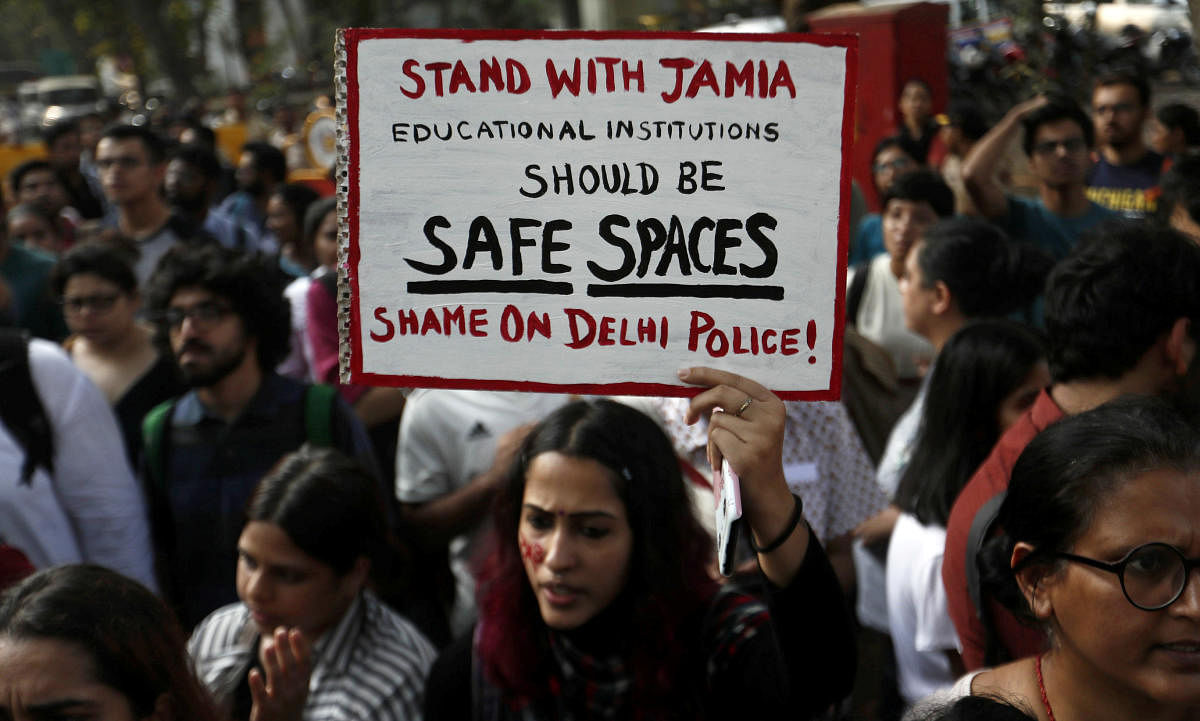 A woman holds a placard during a protest in solidarity with Jamia Millia Islamia university students after police entered the campus on Sunday in New Delhi, following a protest against a new citizenship law, in Mumbai. Reuters