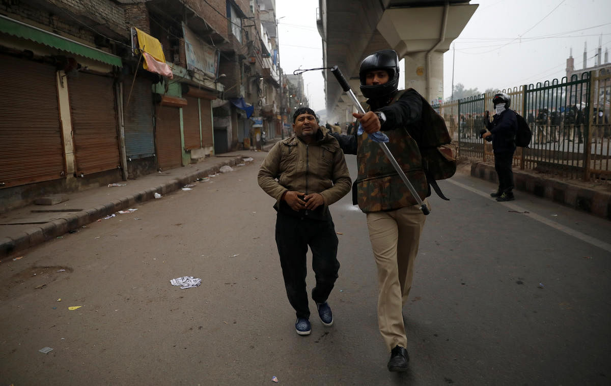 A police officer detains a demonstrator during a protest against a new citizenship law in Seelampur, area of Delhi. Reuters