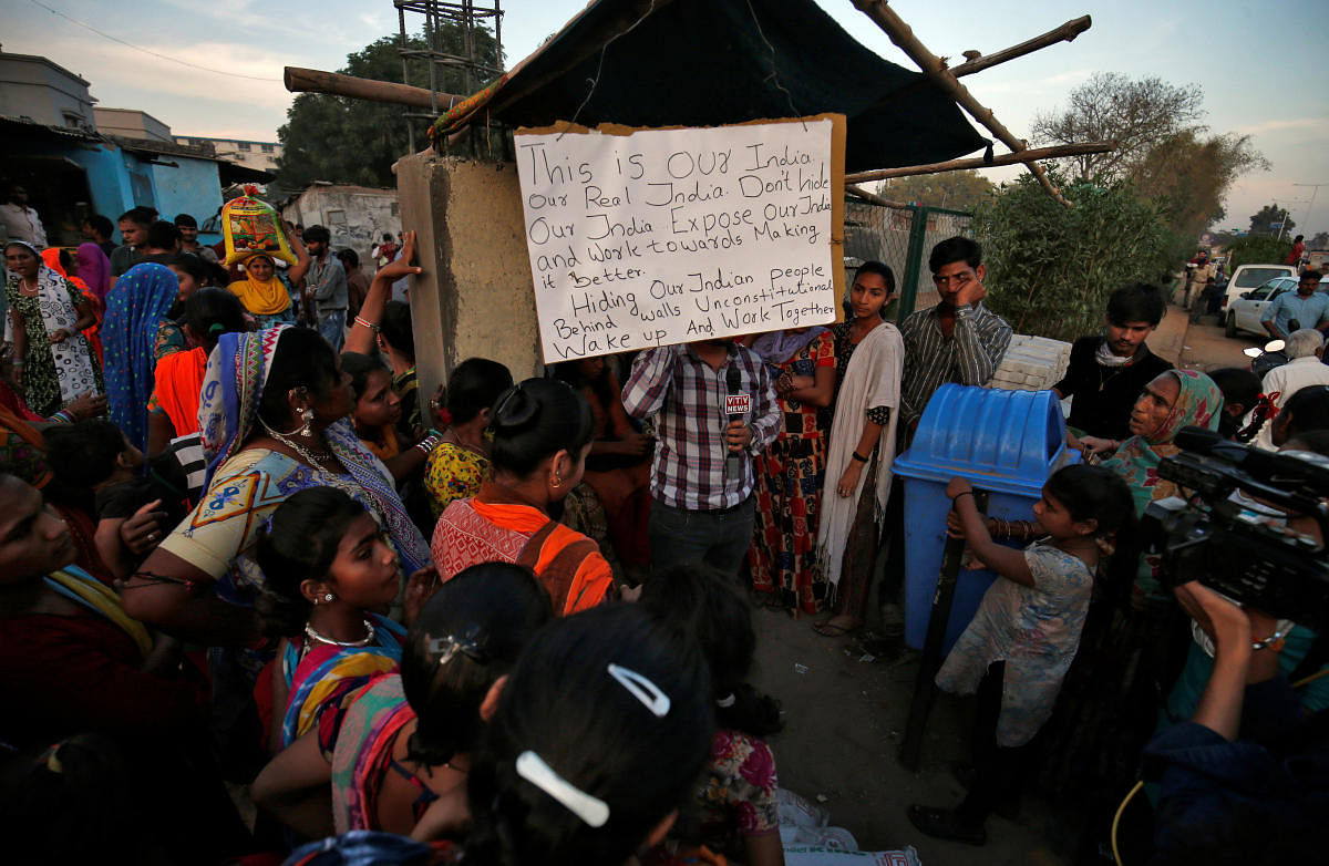 A placard hangs as residents gather to support Aswathy Jwala (not pictured), a social activist, who is on a hunger strike to oppose the building of a wall along a slum area, that authorities said was as built as part of a beautification drive along a route, that U.S. President Donald Trump and India's Prime Minister Narendra Modi will be taking during Trump's upcoming visit, in Ahmedabad, India, February 18, 2020. (Reuters Photo)