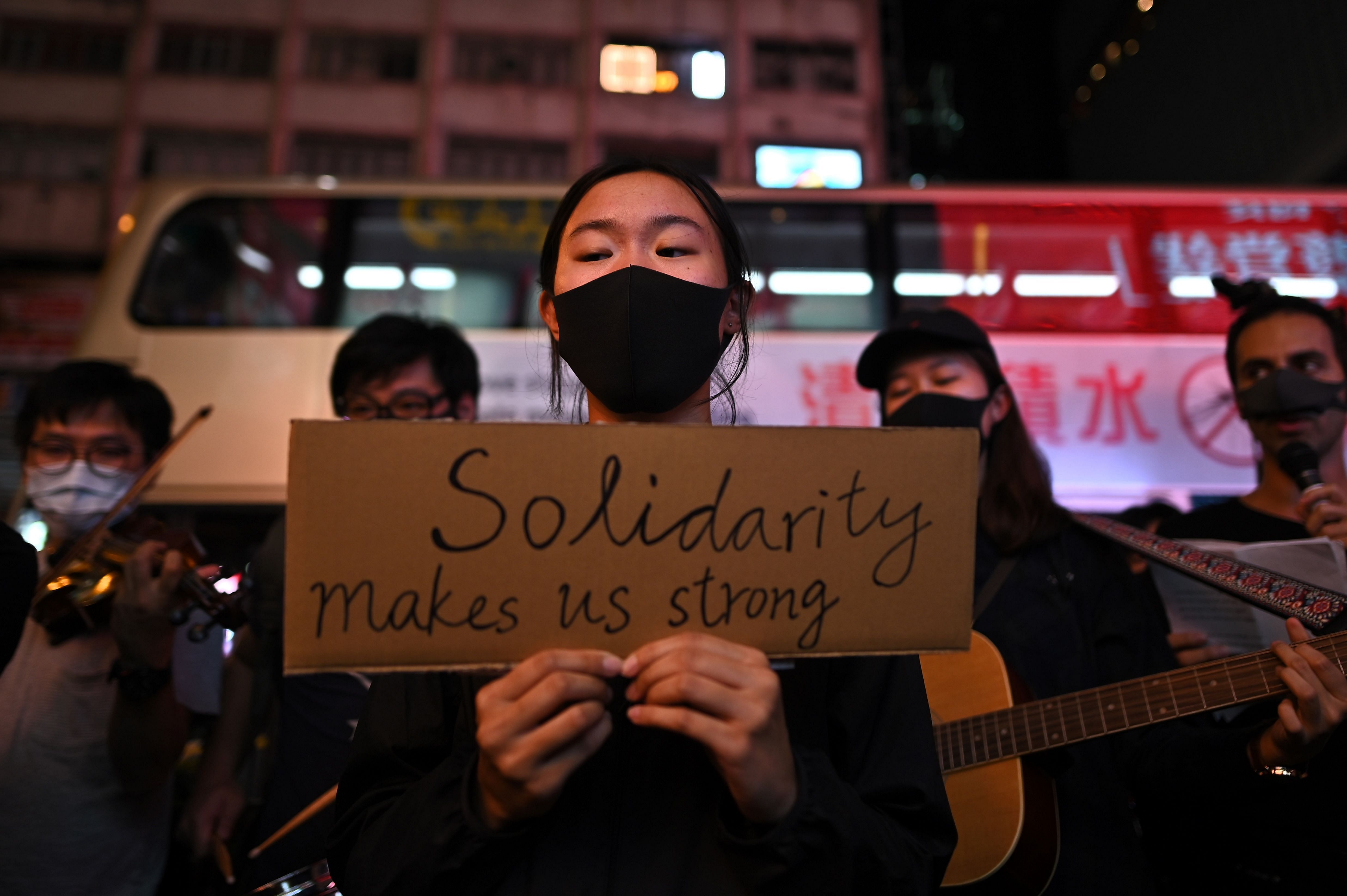 People attend a flash mob singing event outside Chungking Mansions in Tsim Sha Tsui district in Hong Kong on October 23, 2019. - Months of increasingly violent pro-democracy demonstrations in the financial hub were sparked by protests against a now-cancelled extradition law, (AFP)