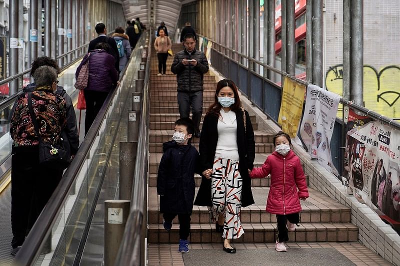 People wearing masks, walk on street in Central, a business district in Hong Kong. (PTI Photo)
