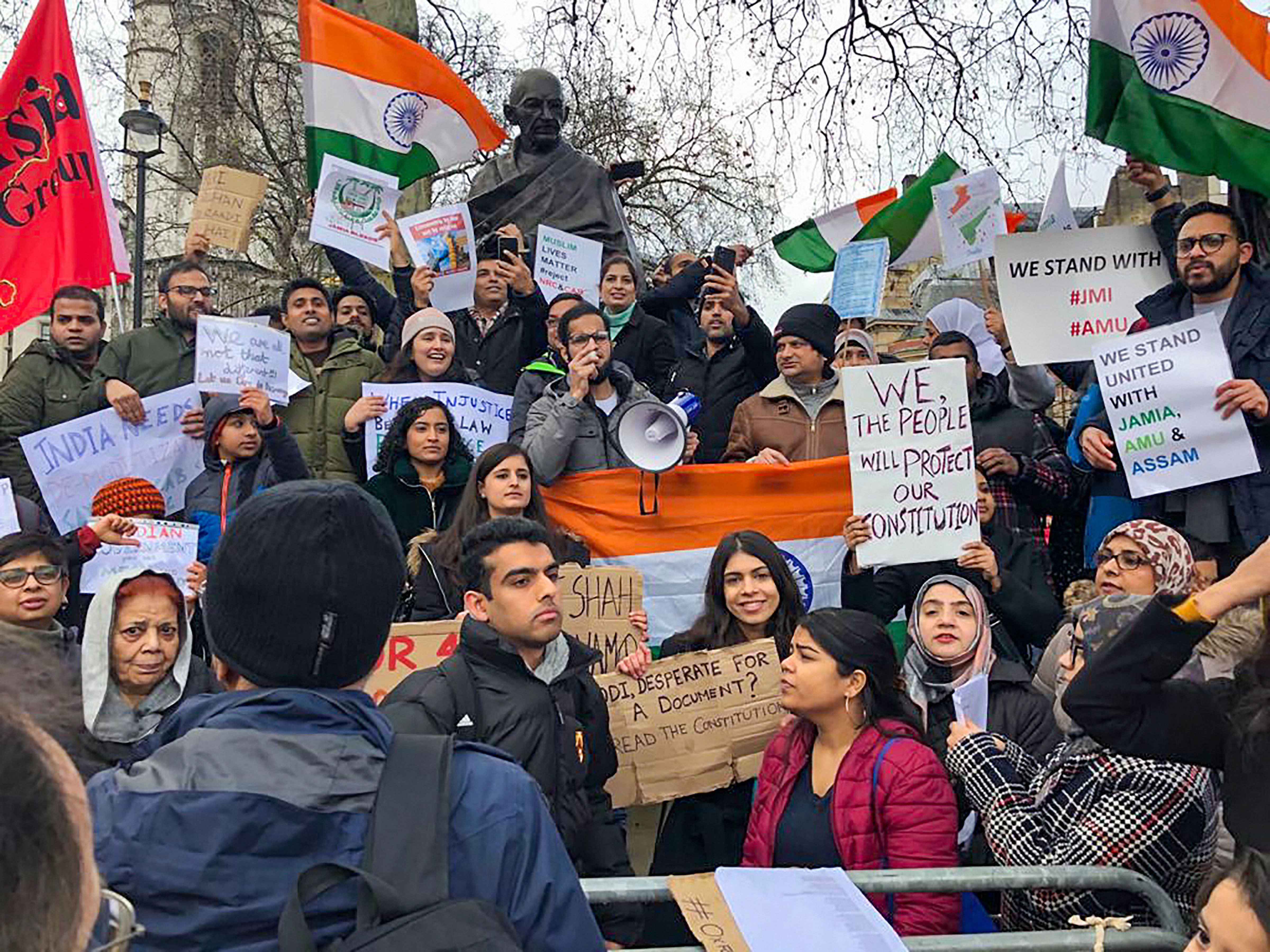 Anti-CAA protesters at the Gandhi statue at Parliament Square in London. (PTI Photo)