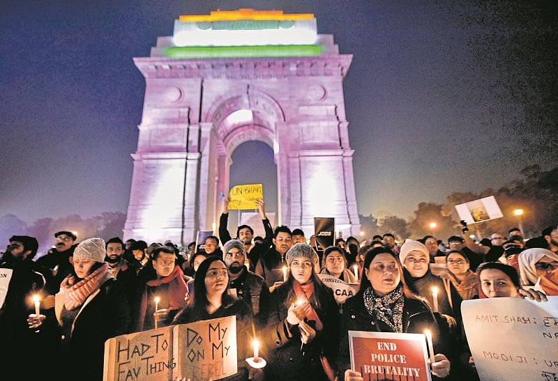 Members of Jamia Teachers Association (JTA) stage a candle light march against the amended Citizenship Act, at India Gate in New Delhi. (PTI Photo)