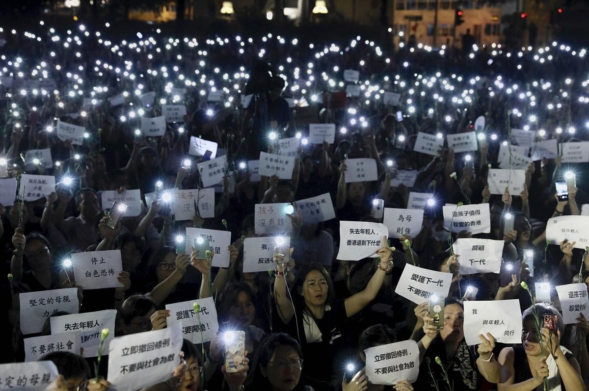 Hundreds of mothers holding placards, some of which read "If we lose the young generation, what's left of Hong Kong", and lit smartphones protest against the amendments to the extradition law in Hong Kong on Friday, June 14, 2019. (AP/PTI)