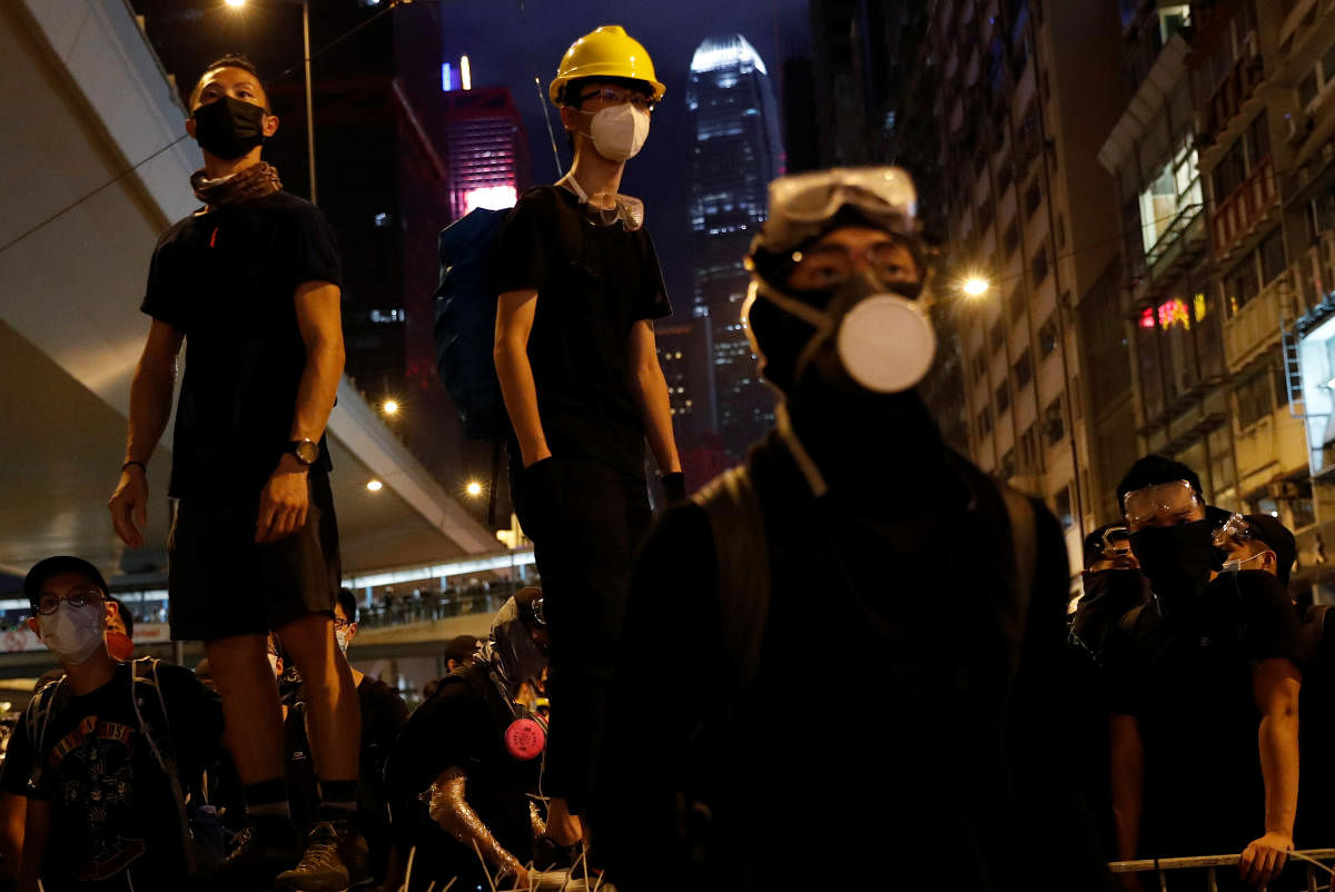 Anti-extradition bill demonstrators stay on barriers as they face riot police, after a march to call for democratic reforms, in Hong Kong, China July 21, 2019. (Photo by Reuters)
