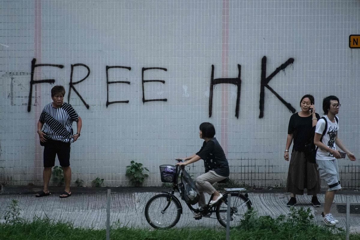 A cyclist rides past graffiti that reads "Free HK" in the Tai Wai area of Hong Kong. (AFP Photo)