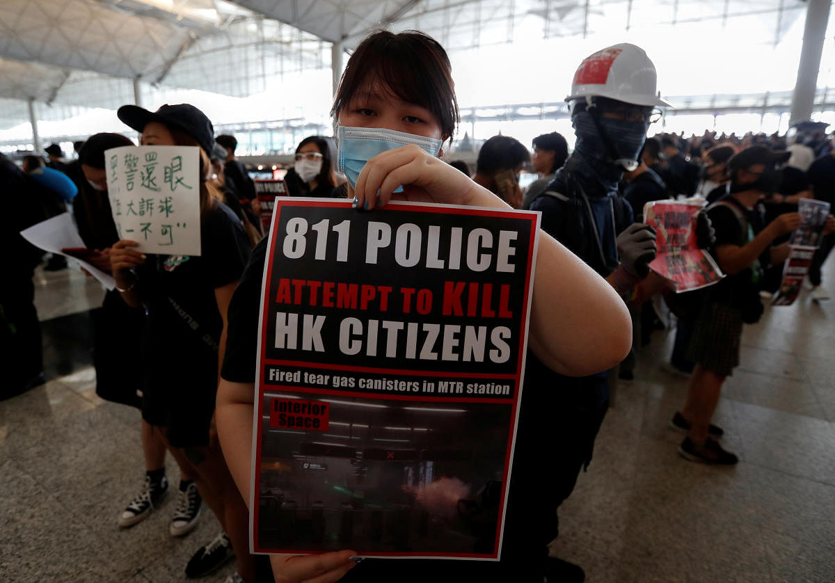 An anti-extradition bill demonstrator holds a placard during a protest at the departure hall of Hong Kong Airport, China. Reuters Photo