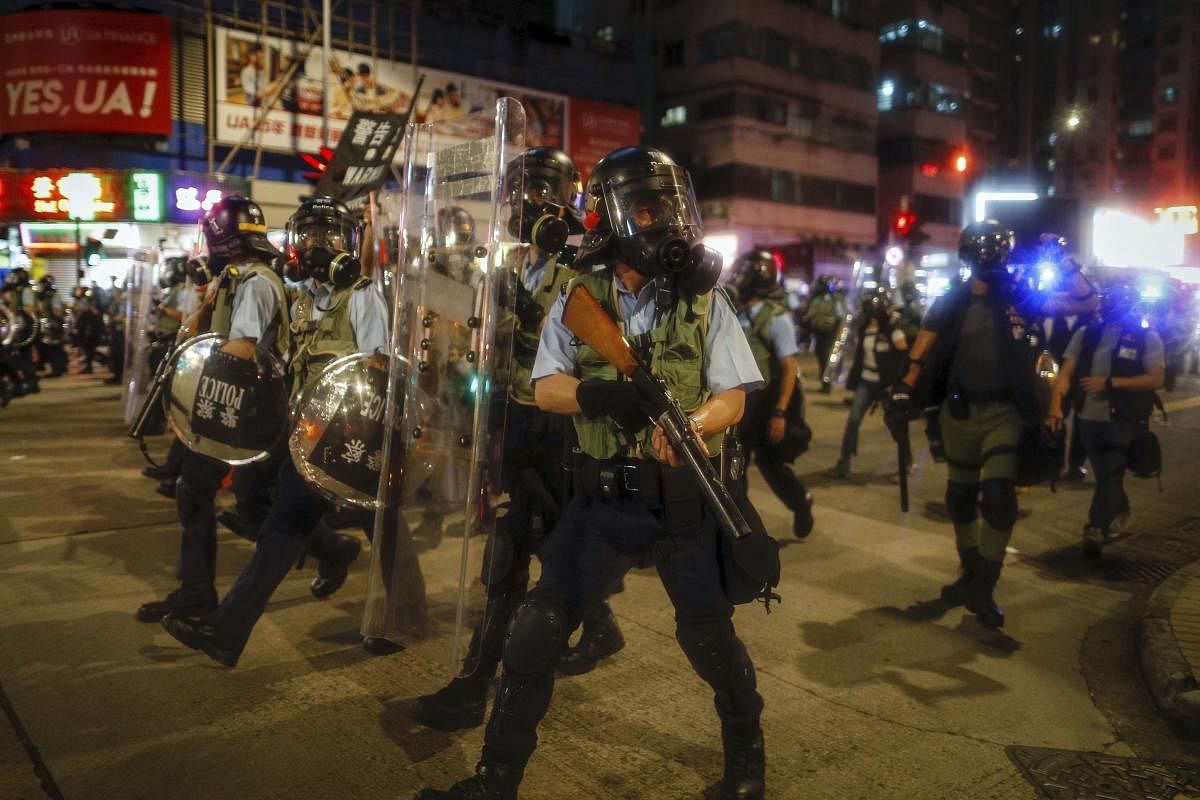 Hong Kong:Police in riot gear march on a street as they confront protesters in Hong Kong on Wednesday, Aug. 14, 2019. German Chancellor Angela Merkel is calling for a peaceful solution to the unrest in Hong Kong amid fears China could use force to quell p