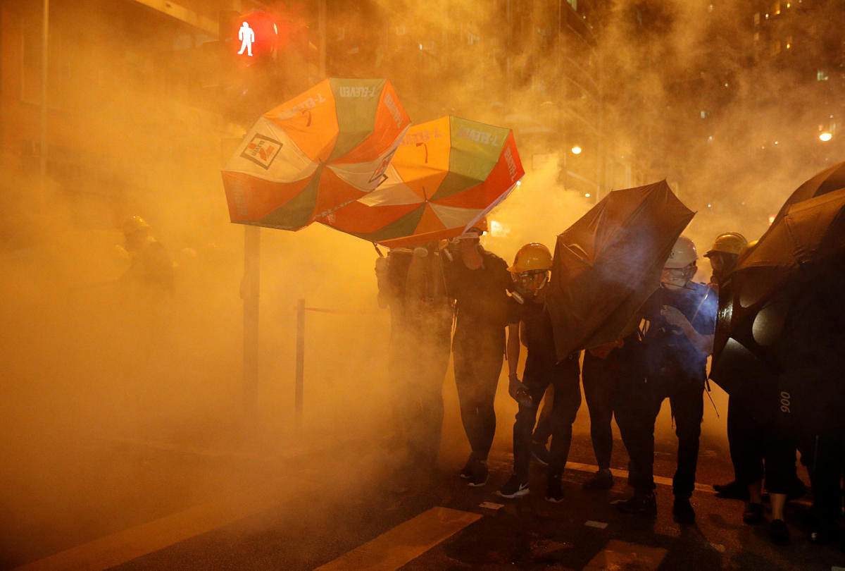 Pro-democracy protesters shield themselves with umbrellas in tear gas as they clash with police in Hong Kong, China July 28, 2019. Picture taken July 28, 2019. REUTERS/Edgar Su