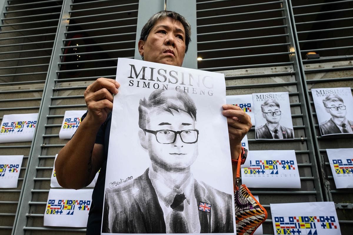 An activist holds an illustration of Simon Cheng during a gathering outside the British Consulate-General building in Hong Kong. (AFP Photo)