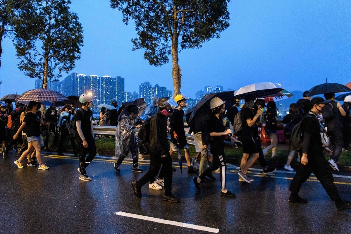 A large group of protesters, try to find a safe area, who left their positions after frontliners told them to leave following the arrival of a police water cannon, during a protest in Tsuen Wan, an area in the New Territories in Hong Kong. AFP