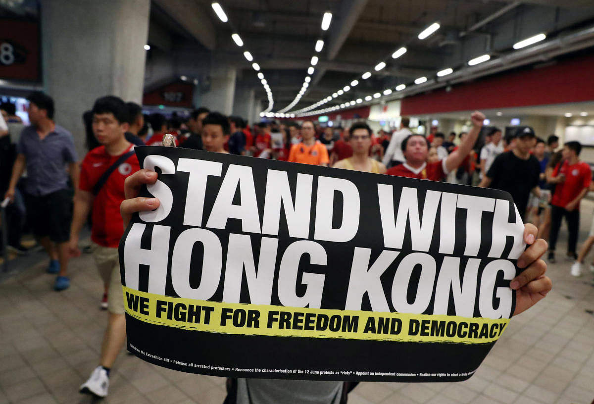 A demonstrator holds a sign in support of anti-government protesters at a football World Cup qualifier match between Hong Kong and Iran, at Hong Kong Stadium. Reuters Photo