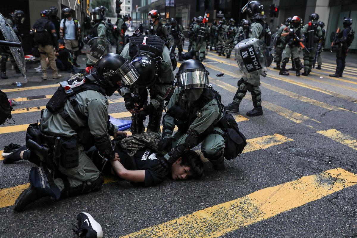 Police detain a man during a flash mob to block roads in Hong Kong. Pro-democracy protesters stepped up on November 13 a campaign of roadblocks and vandalism across Hong Kong that has crippled the international financial hub this week and ignited some of