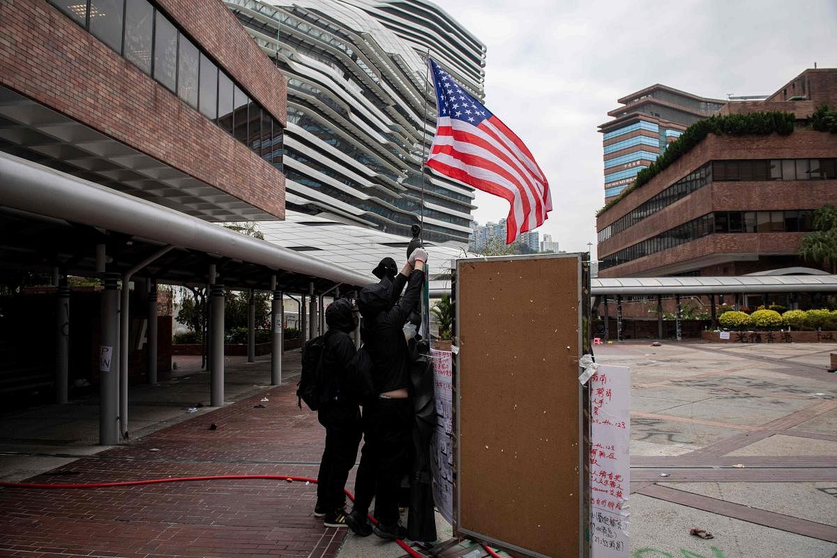 Protesters raise a US flag inside the Hong Kong Polytechnic University in the Hung Hom district of Hong Kong on November 20, 2019. (Photo by AFP)