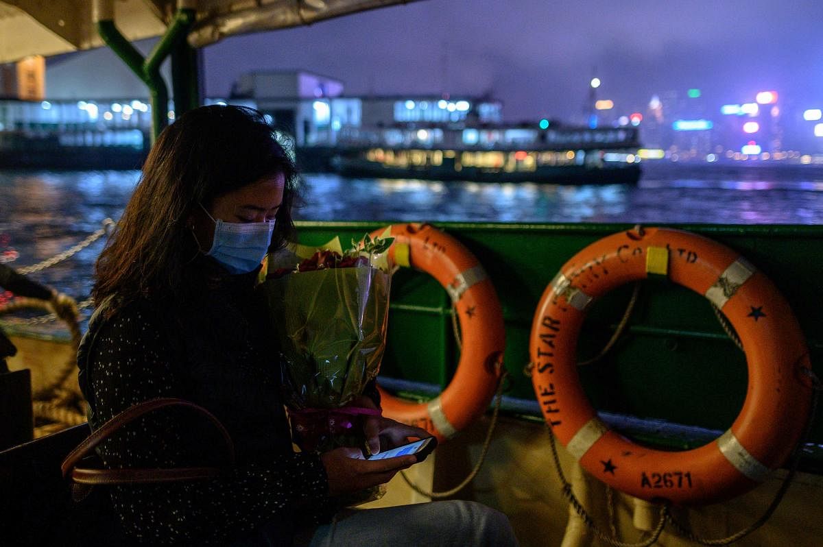 A woman wears a face mask as a preventative measure against the COVID-19 coronavirus as she travels on a ferry from Kowloon to island side of Hong Kong on February 14, 2020. AFP