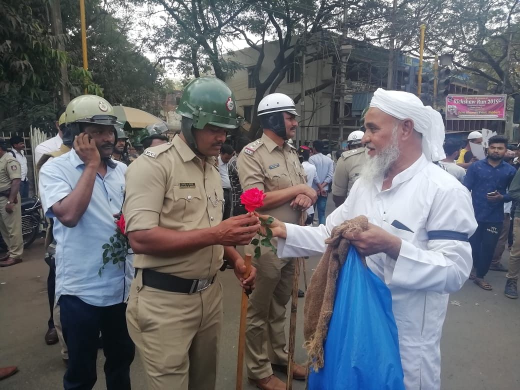 Izaz Ahmed, an business man,  offers roses to policemen deputed on duty at Ambedkar circle in Hubballi during anti-CAA protest