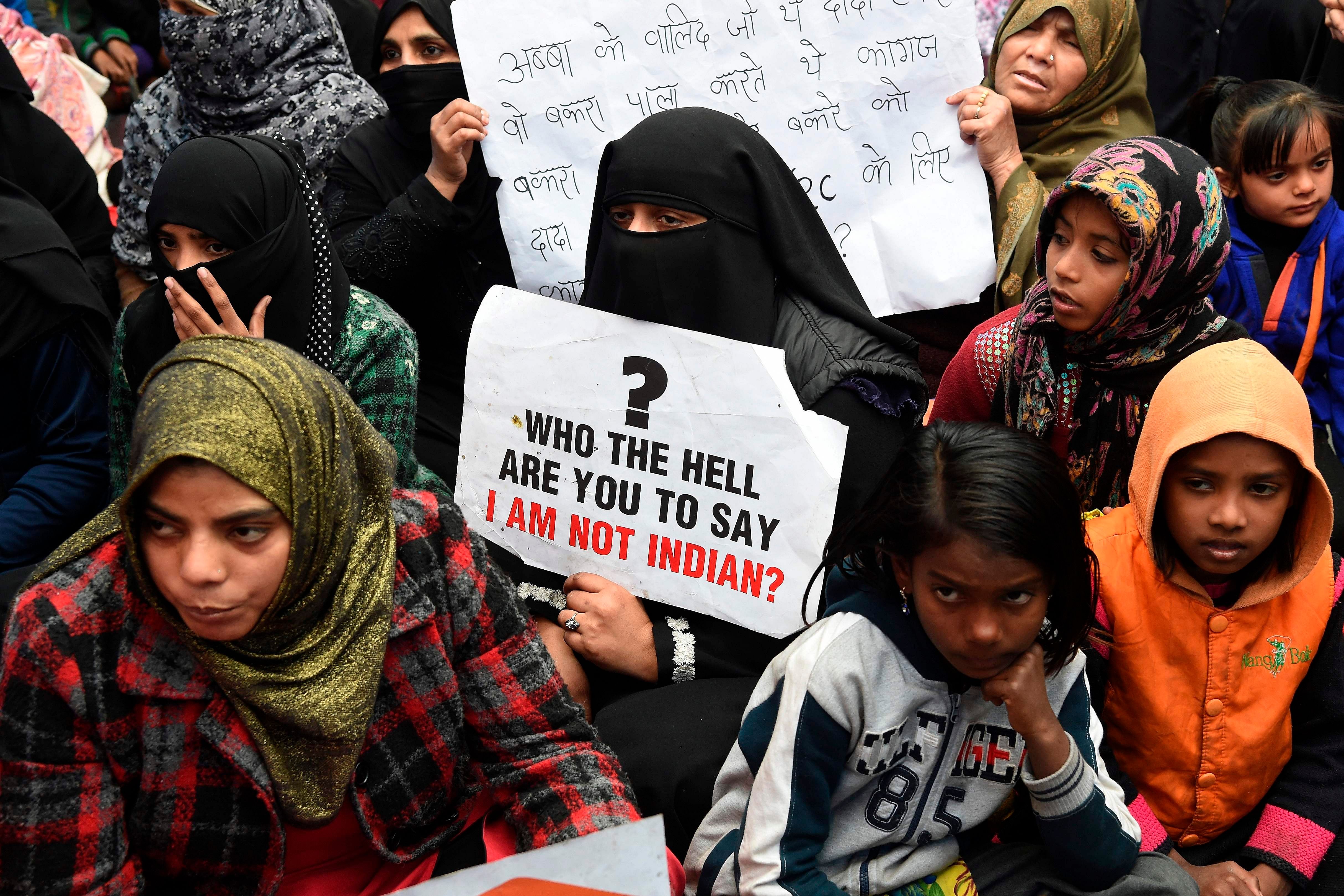 Protesters hold placards as they listen to speakers in Shaheen Bagh area in Delhi. (PTI Photo)