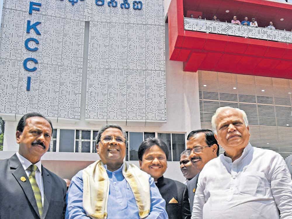 Chief Minister Siddaramaiah in front of the FKCCI centenary building in Bengaluru that was inaugurated on Wednesday.  FKCCI president M C Dinesh (extreme left) and Medium and Large Scale Industries Minister R V Deshpande are seen. DH photo