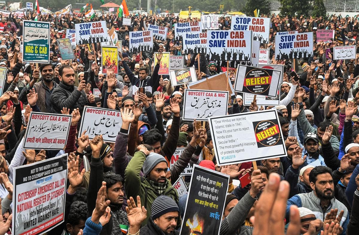 Protesters hold placards as they raise slogans during a demonstration against NRC and Citizenship (Amendment) Act (CAA) (PTI Photo)