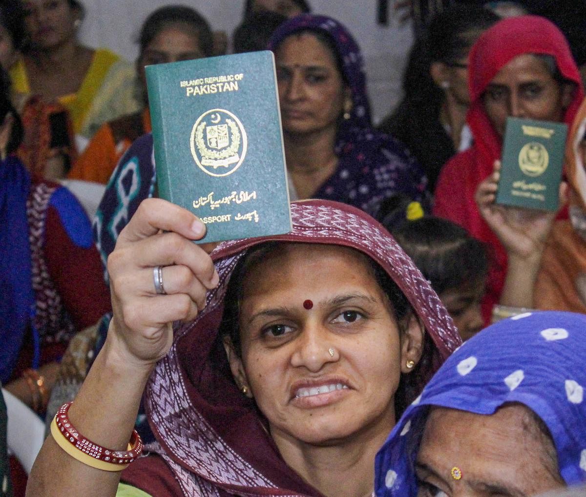Ahmedabad: Hindu refugees who migrated from Sindh province of Pakistan display their passports as they support the Citizenship Amendment Act in Ahmadabad. The Gujarat Legislative Assembly on Friday passed a resolution congratulating the Prime Minister and the Union Home Minister for securing the passage of the Citizenship (Amendment) Act. (PTI Photo)