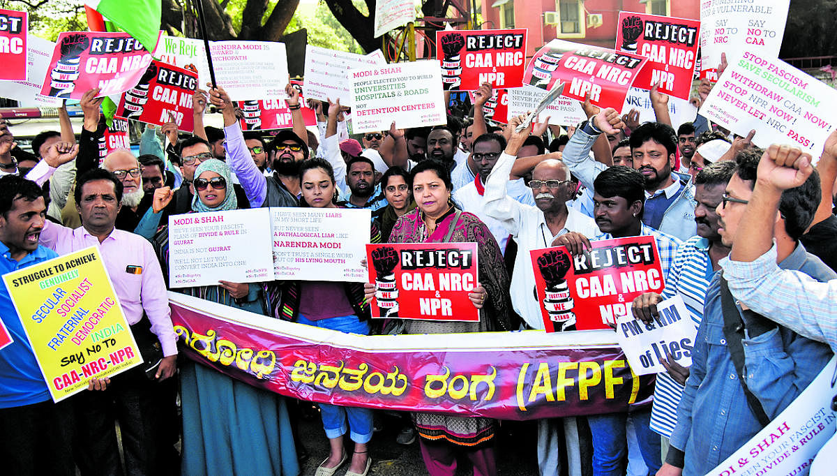 Protesters display placards and raise slogans during a protest against the Citizenship Amendment Act, National Register of Citizenship and National Population Register near Mysore Bank Circle on Monday. DH photo/Janardhan B K
