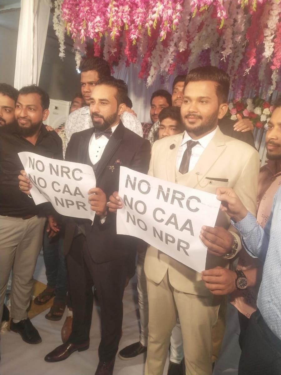 Bridegrooms Mohammed Rilwan and U S Nihal hold posters opposing NRC and CAA at Unity Hall at Kallapu on the outskirts of Mangaluru.