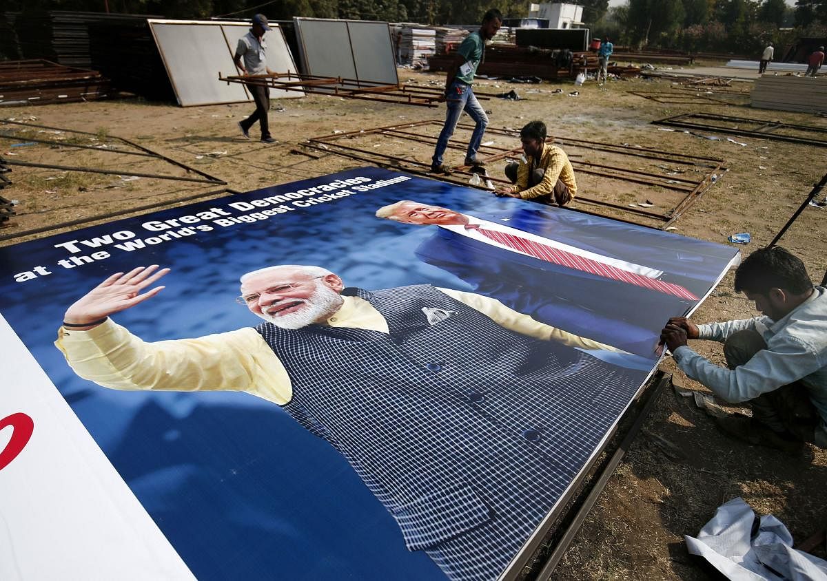 Workers ready a hoarding with pictures of the U.S. President Donald Trump and India's Prime Minister Narendra Modi as preparations are underway for Trump's forthcoming 'Namaste Trump' event, in Ahmedabad, Wednesday, Feb. 19, 2020. (PTI Photo)
