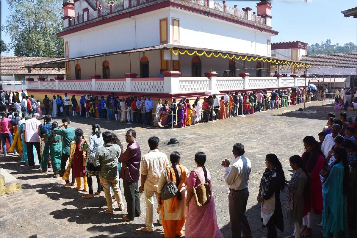 Devotees waiting in a queue for the ‘darshana’ of presiding deity at Omkareshwara Temple in Madikeri on Friday. DH Photo