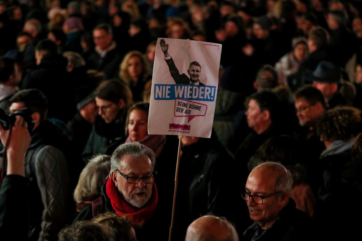 A man holds a placard featuring Regional leader of AfD Thuringia Bjoern Hoecke and the words "Never again" during a vigil in Hanau, near Frankfurt am Main, western Germany. AFP