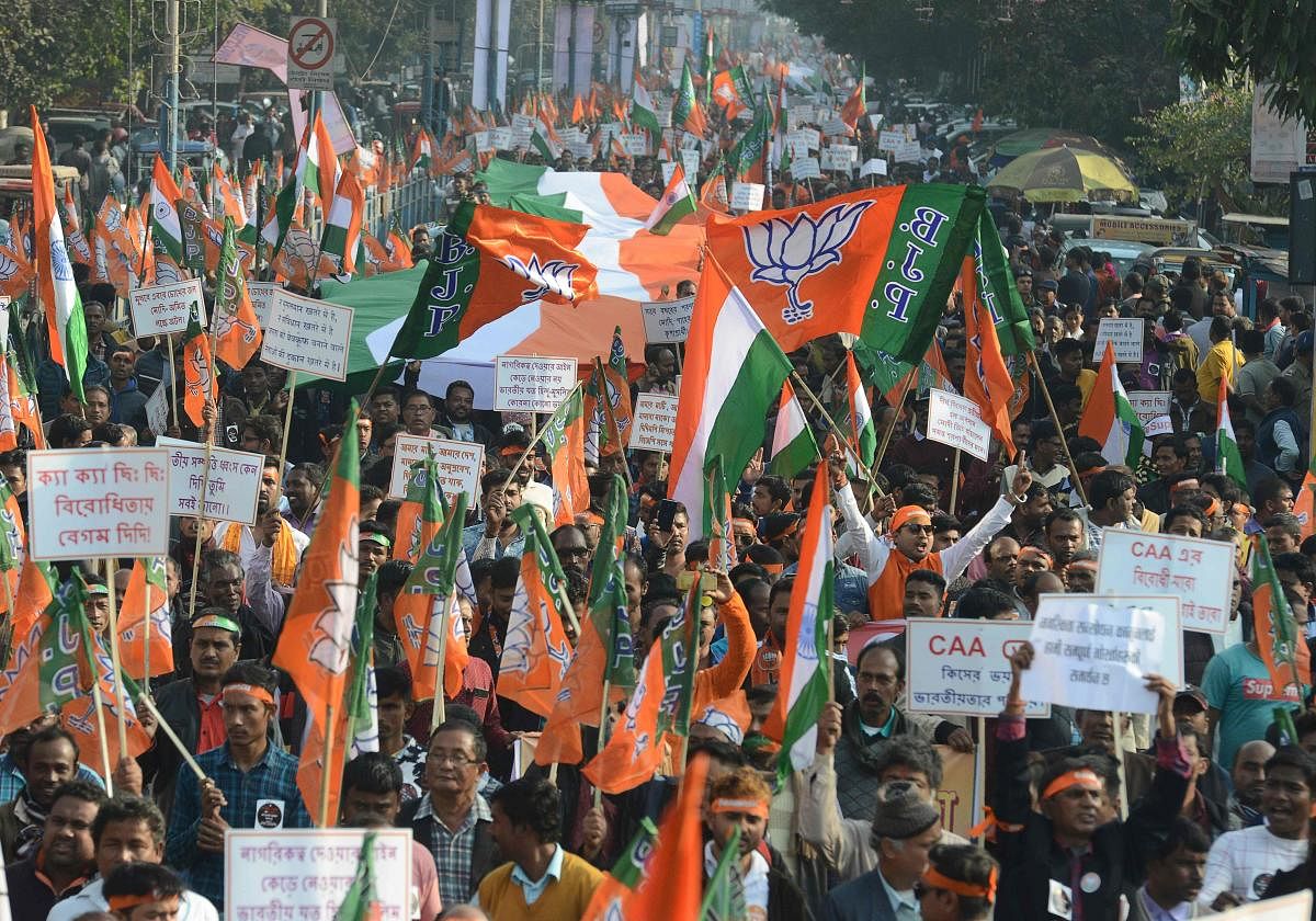 Supporters of the Bharatiya Janata Party (BJP) shout slogans and hold Indian flags during a rally in support of India's new citizenship law. (AFP Photo)