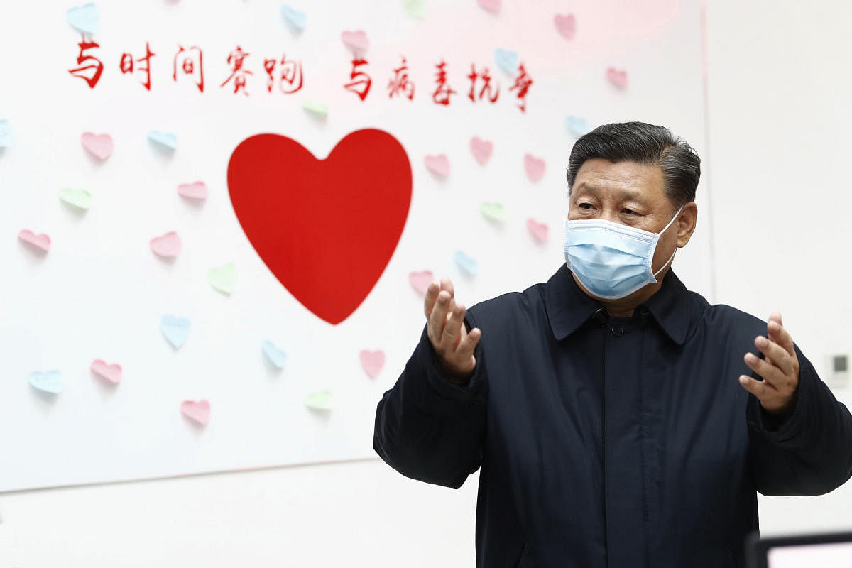Chinese President Xi Jinping gestures near a heart shape sign and the slogan "Race against time, Fight the Virus" during an inspection of the center for disease control and prevention of Chaoyang District in Beijing. AP/PTI