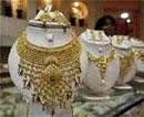 A saleswoman stands behind the showcased gold necklaces at a jewellery showroom in Agartala- Reuters photo