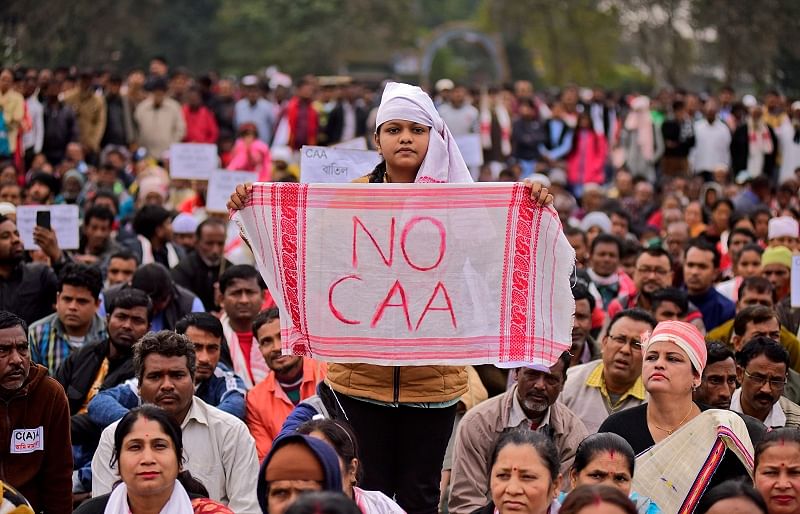 A demonstrator holds a piece of cloth locally known as "Gamosa" during a protest against a new citizenship law in Nagaon district in the northeastern state of Assam. (Reuters Photo)
